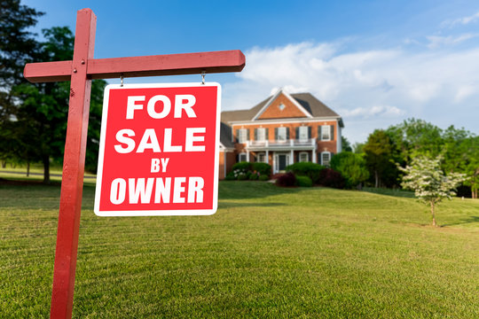 For sale sign in front of large USA home