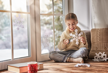 Child makes paper snowflakes © Konstantin Yuganov