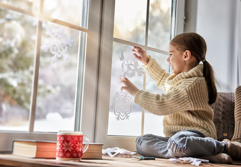 Child makes paper snowflakes © Konstantin Yuganov