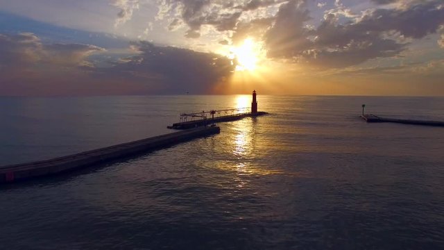 Spectacular, breathtaking sunrise over Lake Michigan, with Algoma Wisconsin harbor,pier, lighthouse; scenic aerial flyover.