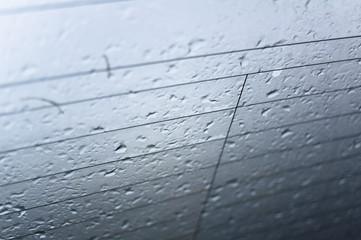 Drops and raindrops on the glass of window. Macro scene of surface with straight black lines. Very low depth of field - abstract background