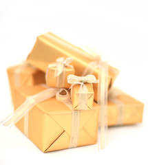Golden gift boxes with golden ribbon on whiter background.