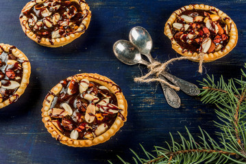 Mini tarts with nuts and caramel on a rustic background, top view, copy space