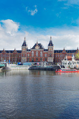 cityscape with central railway station and old town canal in Amsterdam, Holland