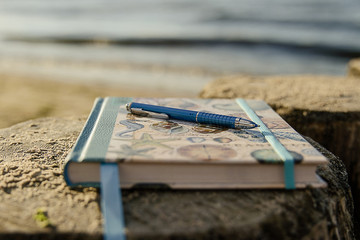 Notizbuch mit Stift am Strand