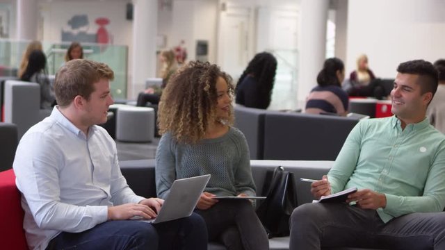 Students studying together in a modern university lobby, pan, shot on R3D