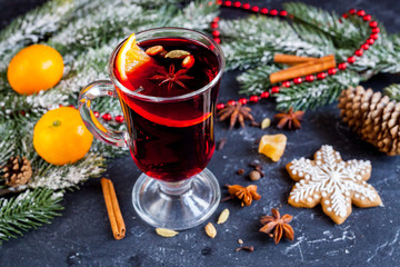 Fototapeta na wymiar Christmas mulled wine with spices in cup on dark background