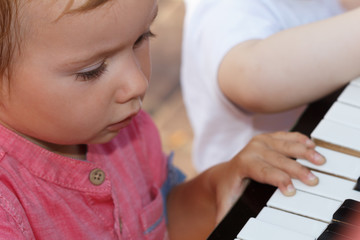 Fototapeta premium Child sings a song and plays piano, happy childhood