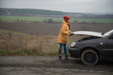 Young woman with broken car