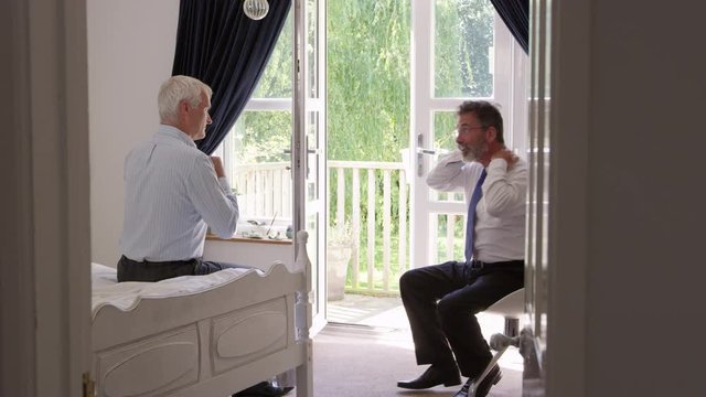 Homosexual Couple In Bedroom Getting Dressed For Work