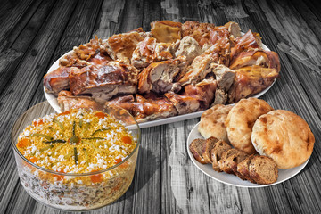 Plateful Of Spit Roasted Pork And Bowl Of Olivier Salad With Pita Bread Loafs and Baguette Slices On Old Cracked Flaky Wooden Garden Table