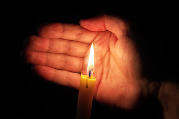 Man hand protect candle fire flame. 