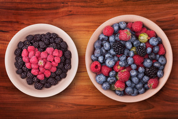 Ceramic plates with heart shaped berries on the wooden table with clipping path. Top view.