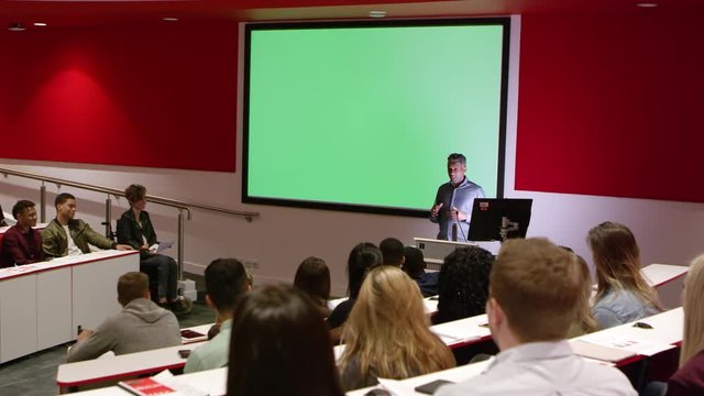 Teacher at lectern in lecture theatre presenting to students, shot on R3D