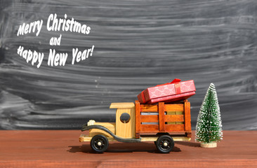 Toy truck carries gifts and a Christmas tree.Christmas background