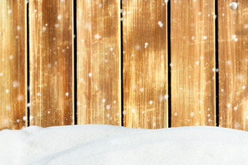 Winter background with snowfall on the old wooden barn wall and snowdrift