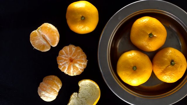Frash tangerines on black background.
