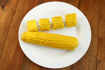 dish with boiled corns on the wooden background