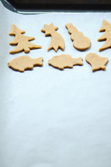 Abstract Christmas food background with cookies molds and flour. Baking Christmas cookies - table, cookie cutters and cookies.