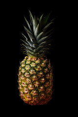 Fresh whole pineapple on a black background