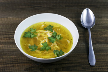 Chicken broth with noodles and parsley leaves. Traditional polish soup.