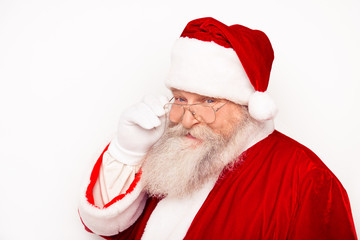 Funny Santa Claus wearing red costume adjusting glasses while st
