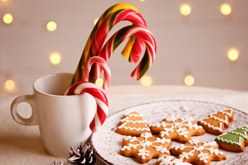 Beautiful Christmas background with gingerbread cookies on white plate with Cup of marshmallows and candy