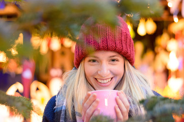 Friendly young woman enjoying a hot beverage