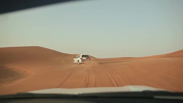 Desert Safari SUVs bashing through the arabian sand dunes. View from the car 8.