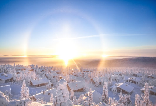 Snow covered cabins with sun halo, Lapland, Finland, Scandinavia, Europe