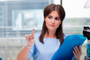 Young woman pressing buttons in lab
