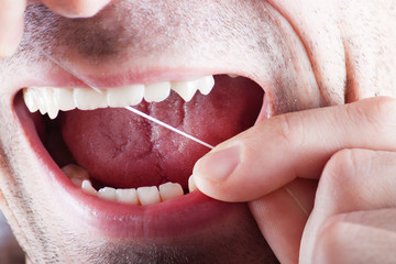 Obraz premium New dental floss on the background of the person. 