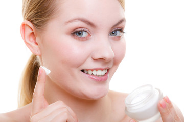 Woman applying face cream with her finger