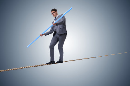 Businessman doing tightrope walking in risk concept
