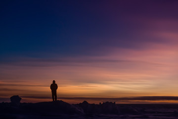 Silhouette of person watching sunset over Antarctica