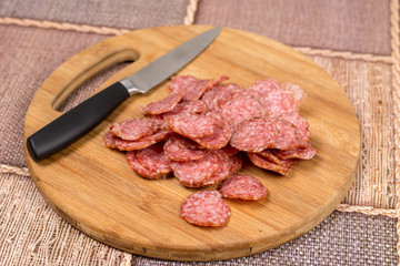 Flat lay overview sliced sausage on the wooden board