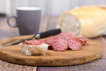Sliced sausages on the wooden board with bread