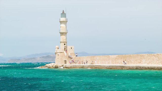 Chania Historical Lighthouse on Crete Island in Greece with Wind Blowing Blue Mediterranean Sea Water on a Sunny Day