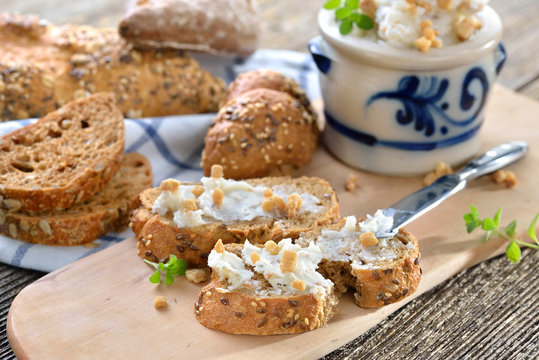 Deftiges Griebenschmalz im Schmalztopf mit rustikalem Brot serviert - Hearty lard with greaves and onions in a rustic stoneware pot served with fresh corn bread