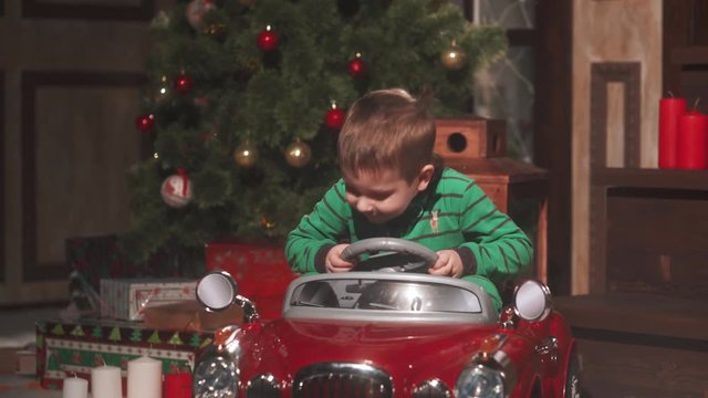 Boy riding a tiny car at xmas