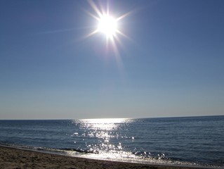Sun starburst over beach on lake Michigan