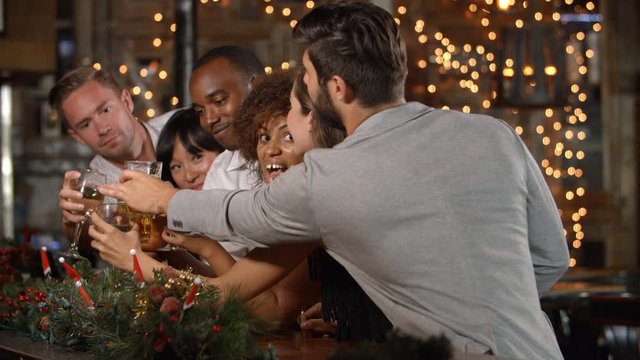 Friends making a toast at a Christmas party in a bar