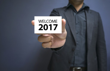 men in suit holding white Label WELCOME 2017