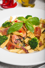 A delicious fresh gourmet Italian strozzapreti pasta dish, with pancetta, italian sausage, broccoli, vegetables, topped with fresh basil.