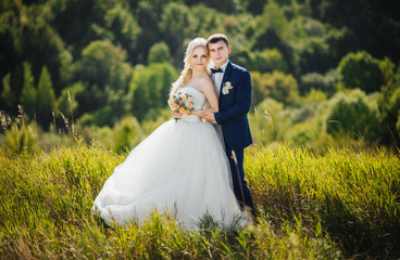 Young couple in love, groom and bride in wedding dress at the nature. Wedding. Wedding day. Bridal...