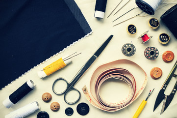sewing tools on white fabric background. over light, retro tone  and high contrast