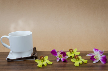 Coffee cup and orchid on wooden table