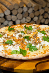 Gourmet goats cheese, mozzarella and truffle pizza served on a rustic wooden board