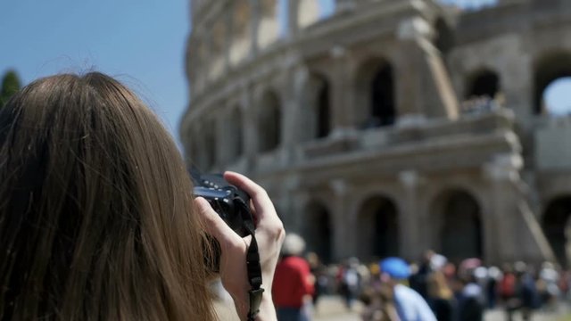 Young woman taking picture of Colosseum on camera, enjoying hobby on vacation