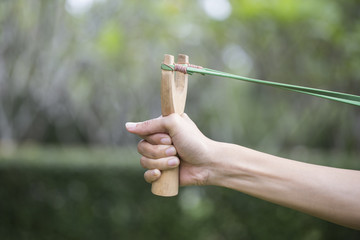 Hand pulling slingshot preparing to shoot a goal, business conce